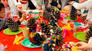 Niños decorando piñas, en evento corporativo